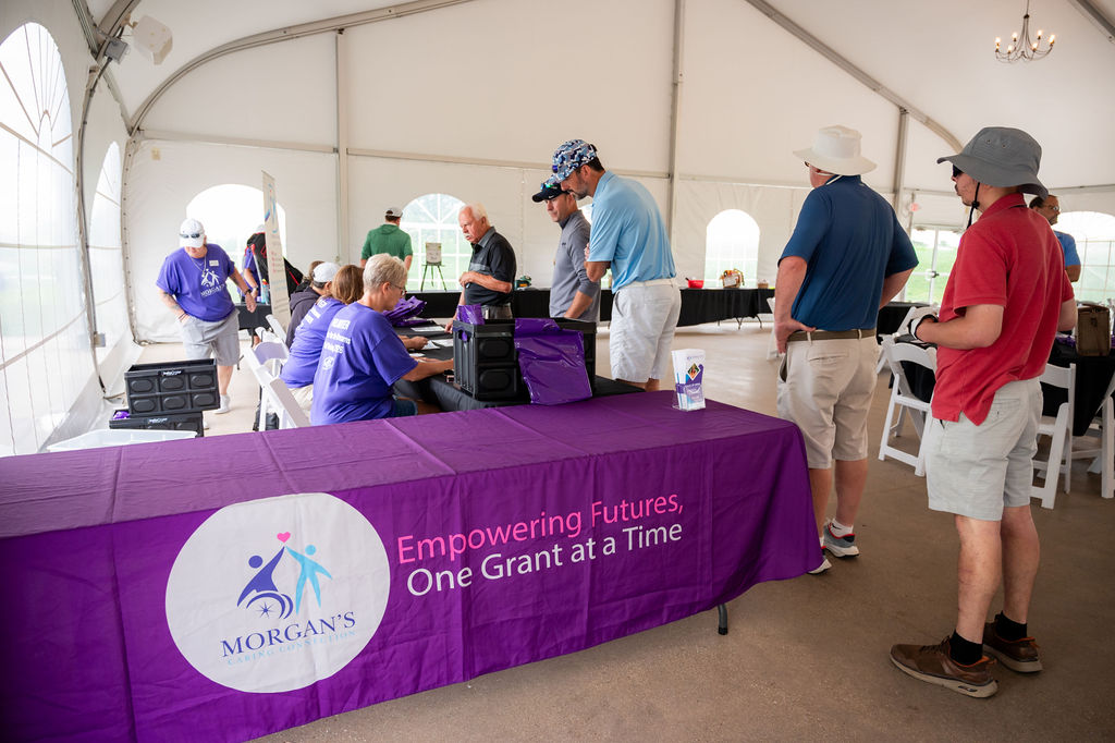Volunteers welcome golfers at the MCC Drive for Dreams registration tent